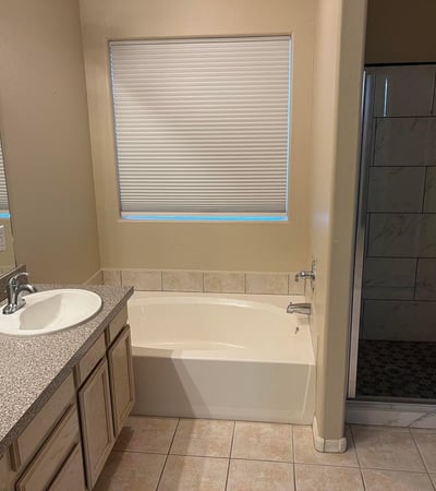 The spacious primary bath offers dual vanities, a soaking tub, an updated walk-in shower, and plenty of natural light, creating a comfortable retreat after a long day.