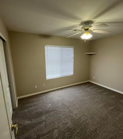 Bright and spacious, this secondary bedroom offers plush carpeting, natural light, a ceiling fan, and flexible space suitable for a variety of living needs.