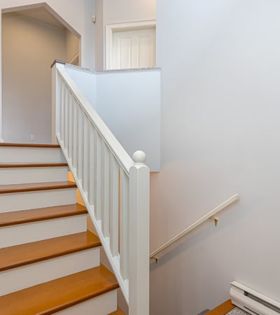 This inviting staircase features wooden steps and natural light, leading to additional living spaces upstairs.