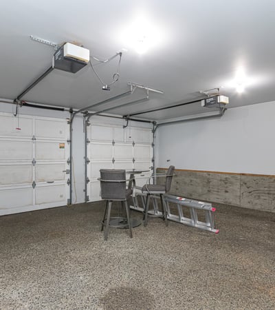 Spacious garage with ample room for storage, featuring high ceilings and convenient overhead lighting.