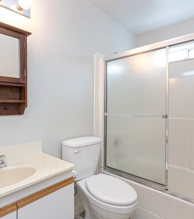 This well-equipped bathroom features a sleek shower enclosure and convenient storage space, perfect for everyday use.