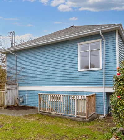 This well-maintained blue home features a spacious backyard, perfect for outdoor activities and gardening.