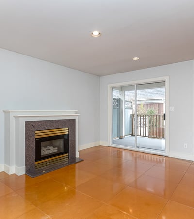 Bright and open living space featuring a cozy fireplace and access to a private outdoor balcony.