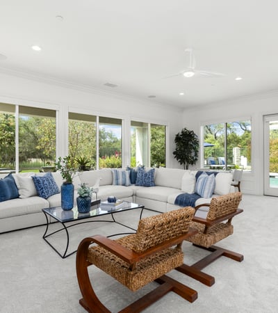 Spacious living area with large windows, offering abundant natural light and direct views of the pool.
