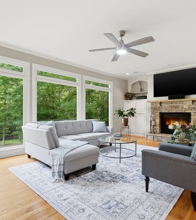 Bright and inviting living room featuring large windows, cozy fireplace, and spacious layout for entertaining.