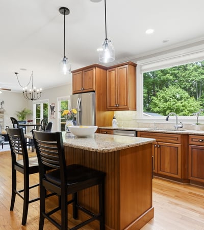 Bright and functional kitchen featuring wooden cabinetry, granite countertops, and a spacious island perfect for gatherings.