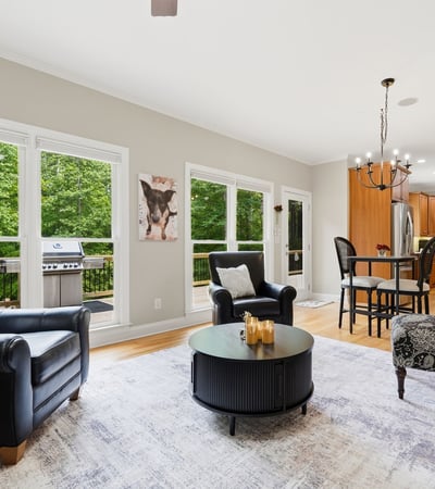 Spacious living area features large windows, modern kitchen amenities, and outdoor access for entertaining.