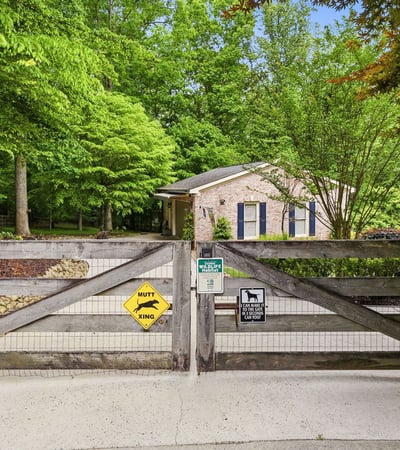 Nestled amid lush greenery, this property features a welcoming entrance and ample outdoor space for relaxation.