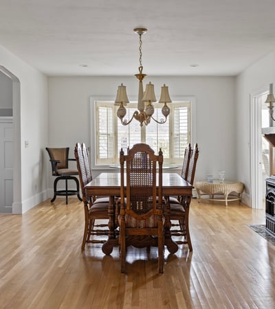 Spacious dining area features ample natural light, classic furnishings, and a cozy fireplace for gatherings.