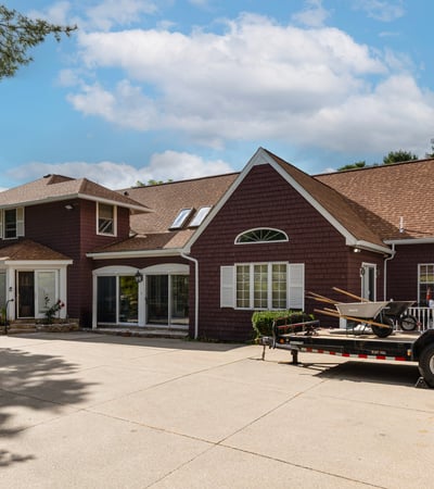 Spacious home featuring a large driveway, bright interiors, and a welcoming outdoor space for gatherings.