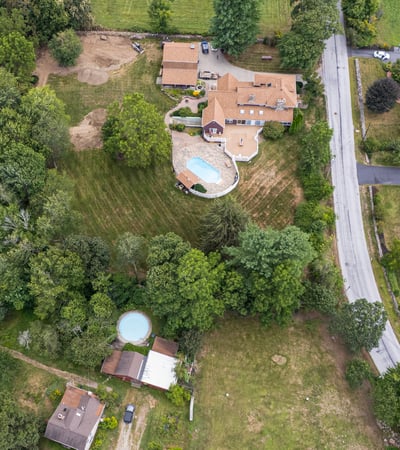 Spacious property with multiple buildings, expansive lawns, and a pool, situated near scenic landscapes and easy access roads.