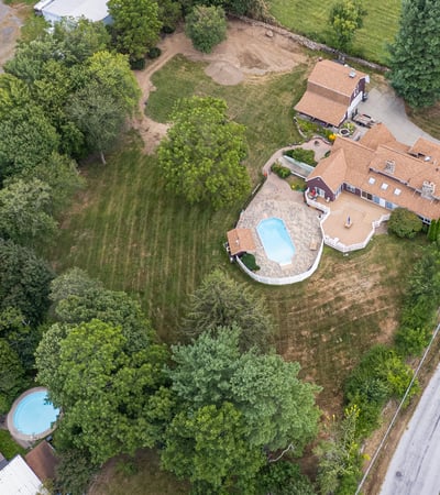 Sprawling property with two pools, vibrant greenery, and ample space for outdoor activities and relaxation.