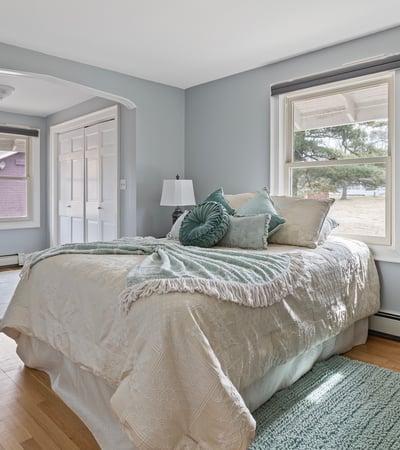 Bright bedroom featuring large windows, natural light, and ample closet space, perfect for relaxation and comfort.