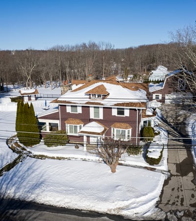Spacious home on a large lot, featuring expansive outdoor areas and nearby wooded surroundings.