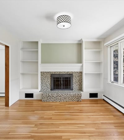 Bright and airy living space featuring large windows and a cozy fireplace for inviting gatherings.
