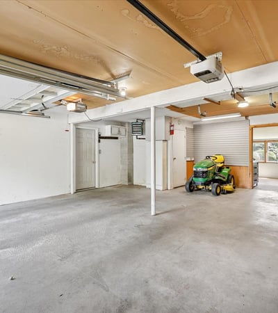 Spacious garage with ample room for storage and vehicles, featuring bright overhead lighting and easy access.