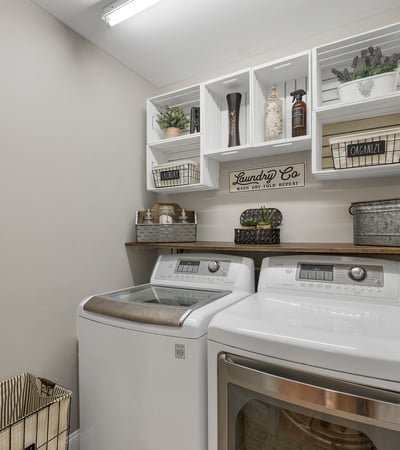 Bright laundry room features modern appliances and organized shelving for convenient storage and utility.
