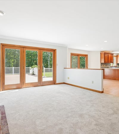 Bright open living space featuring a fireplace, large windows, and seamless access to outdoor entertaining.