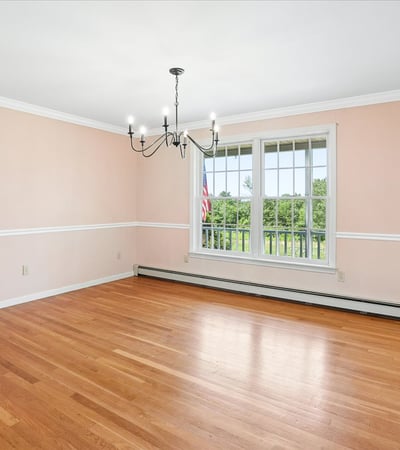 Spacious room with abundant natural light, featuring hardwood floors and a picturesque view. Perfect for customization.