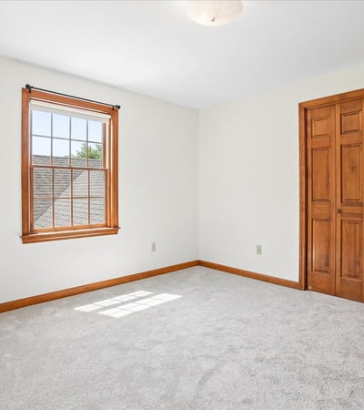 Bright and airy room featuring large windows, ample natural light, and well-crafted wooden closet doors.