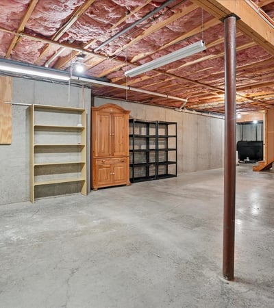 Spacious unfinished basement featuring ample storage options and potential for customization to suit your needs.