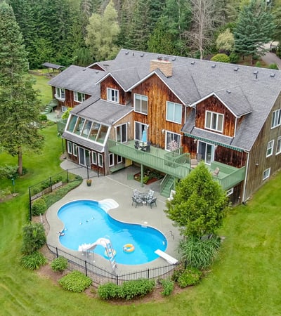 Expansive property featuring a private pool, lush greenery, and multiple outdoor spaces for relaxation and entertainment.