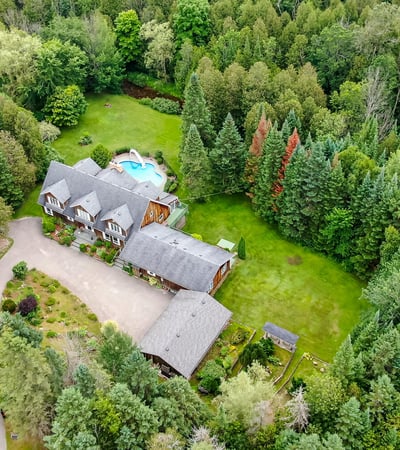 Discover a spacious retreat surrounded by lush greenery, featuring a swimming pool and expansive outdoor area.