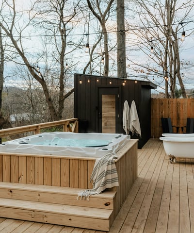 Discover a private outdoor oasis featuring a relaxing hot tub and a secluded sauna amid scenic woodlands.