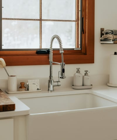Modern kitchen featuring a spacious farmhouse sink and scenic window, perfect for culinary experiences.