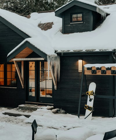 Cozy mountain retreat with ski-in access, featuring a snow-covered exterior and inviting entryway.