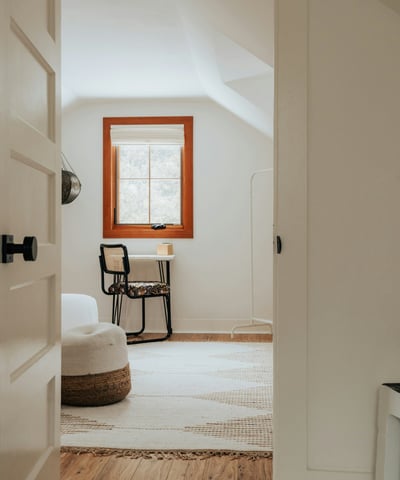 Bright and open room featuring a cozy workspace and unique architectural details, perfect for relaxation or creativity.