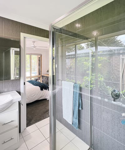 Modern bathroom featuring a spacious shower, sleek fixtures, and a seamless view of the landscaped garden.