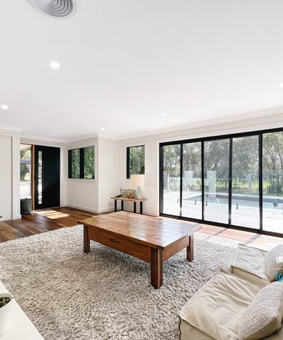 Spacious living area features large windows, abundant natural light, and direct access to outdoor spaces.