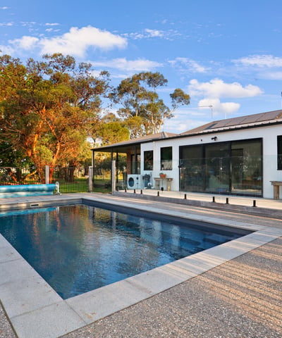 Contemporary home featuring an inviting pool area, surrounded by lush landscaping and ample outdoor space for relaxation.