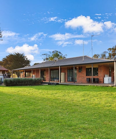 Spacious home set on expansive grounds, featuring large windows and a seamless indoor-outdoor living experience.