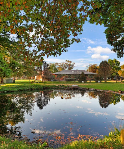 Expansive outdoor space featuring a tranquil pond, surrounded by lush greenery and scenic views.