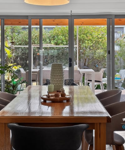 Bright dining area opens to a lush outdoor space, perfect for gatherings and entertaining.