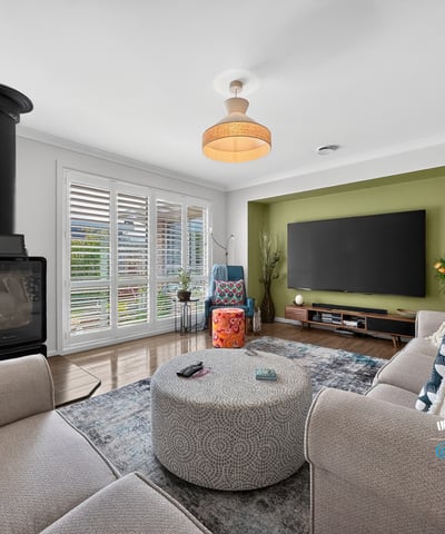 Spacious living area featuring a cozy fireplace, modern entertainment setup, and vibrant accent wall.