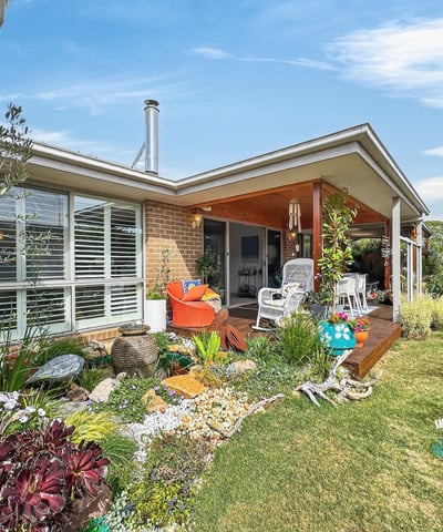This inviting home features a spacious patio surrounded by vibrant landscaping, perfect for outdoor gatherings.