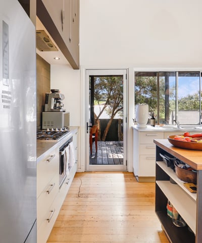 Bright kitchen featuring modern appliances and seamless access to a deck, perfect for entertaining.