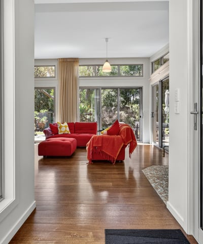 Bright and open living space features large windows and direct access to lush outdoor views.