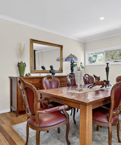 Inviting dining space featuring a large wooden table, classic furnishings, and abundant natural light.