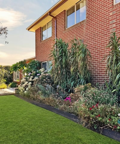 Well-maintained backyard surrounded by vibrant landscaping, perfect for outdoor gatherings or relaxing afternoons.