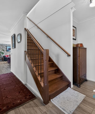 Spacious entryway with natural light, featuring a classic staircase and inviting living spaces beyond.