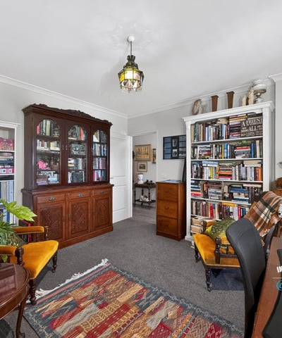 Cozy home office with built-in bookshelves, vintage furnishings, and ample natural light for productivity.