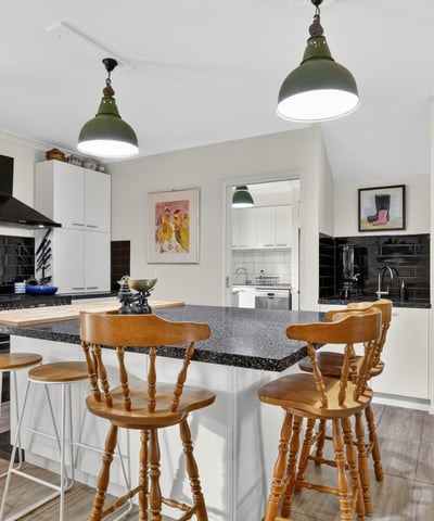 Modern kitchen featuring a spacious island, sleek cabinetry, and ample natural light flowing throughout the open layout.