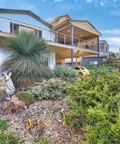 Modern home featuring a spacious design, lush landscaping, and panoramic views in a desirable neighborhood.