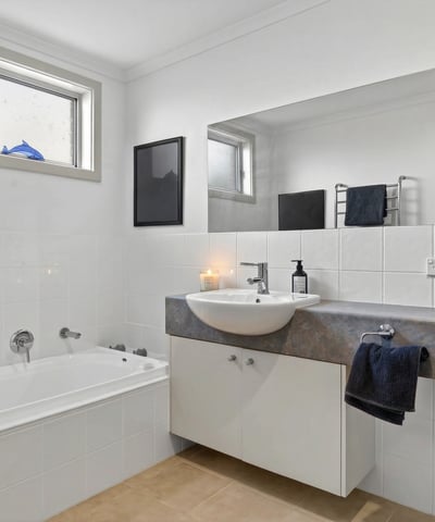 Modern bathroom featuring a spacious tub, sleek countertop, and ample natural light from large windows.