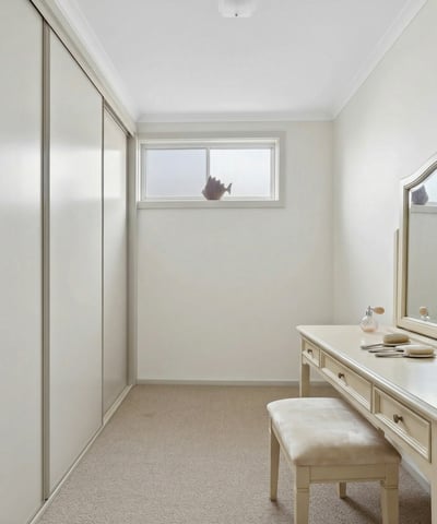 Bright and spacious room featuring ample storage and a versatile vanity area, perfect for personal retreat.