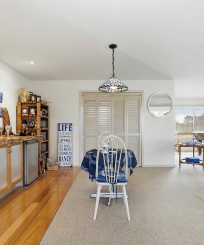 Spacious open-concept living area with natural light, functional bar, and leisure space for entertaining.